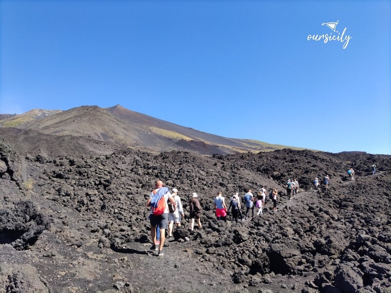 Hikers on lava field of Etna